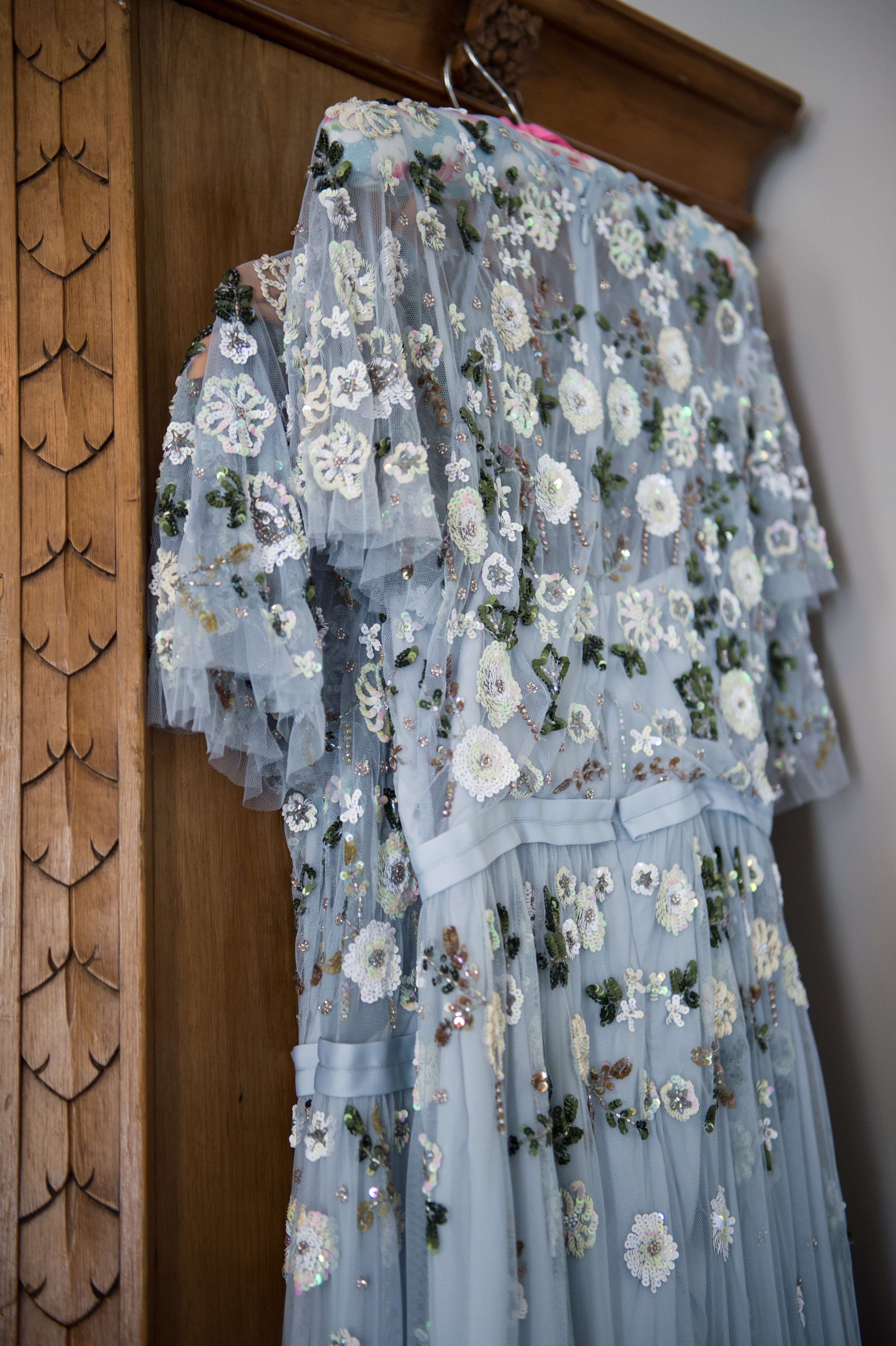blue beaded floral bridesmaid dresses on a wardrobe